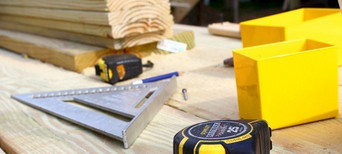 Werkzeuge und Holzbretter auf einer Baustelle – Präzision und Handwerkskunst bei der Holzmontage.